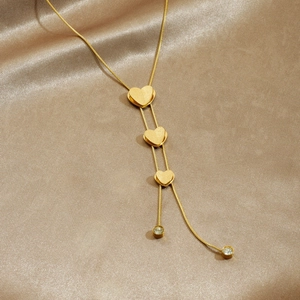 Gold plated stainless steel necklace featuring frosted 3D hearts and crystal fringe tassels