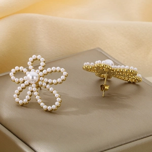 Elegant gold hollow flower petal earrings with pearl center in a front and side view