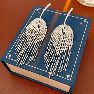 Détail de boucles d'oreilles pampilles en argent avec strass sur un coffret cadeau