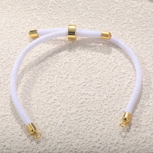 Close-up of white braided Milan cord bracelet with adjustable gold-plated slider clasp