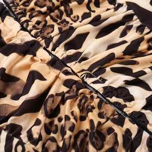 Close-up detail of leopard print fabric with ruching texture and a high-quality zipper seam
