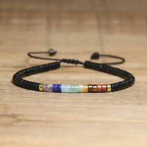 Close-up of handmade woven bracelet with natural stones and adjustable black cord