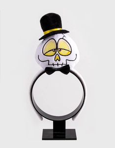 Detail of plush Halloween headband with skull, black top hat and yellow accents