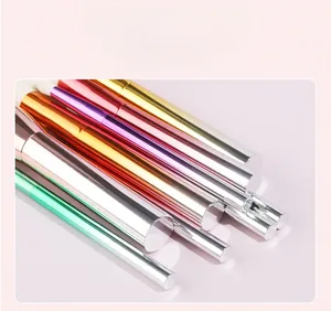 Close-up of ergonomic makeup brush handles with vibrant metallic gradient plating