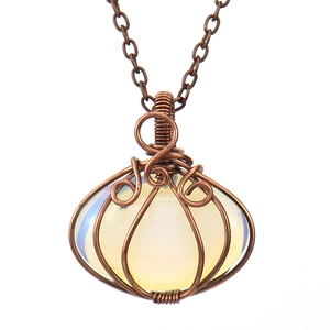 Detail of wire-wrapped pumpkin pendant featuring oval opalite stone and bronze link chain