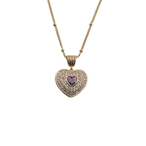 Detailed shot of golden heart pendant with purple gemstone and pavé-set crystals