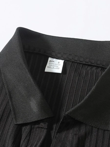 Detail of the black vertical striped polo shirt collar with care label and inner lining