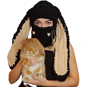 Detail of black knitted balaclava with long rabbit ears, metal rings and chain accents