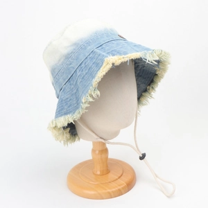 Detail of washed denim bucket hat featuring frayed edges and adjustable windproof strap