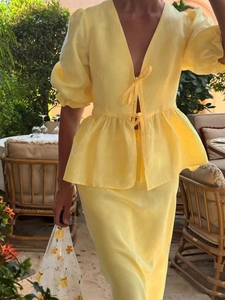 Detailed texture of yellow linen V-neck puff sleeve top and matching skirt set