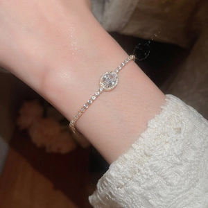 Macro shot of an oval zircon bracelet with pavé-set crystals on a gold-tone band