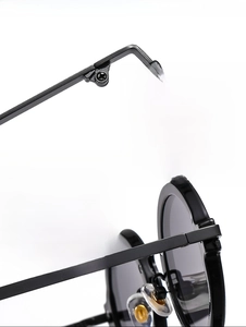 Detail of durable metal hinges and textured frame on round punk style sunglasses