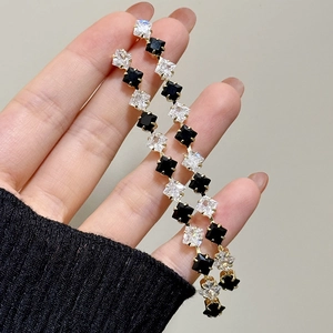 Elegant long crystal dangle earrings with black and white square stones in gold setting