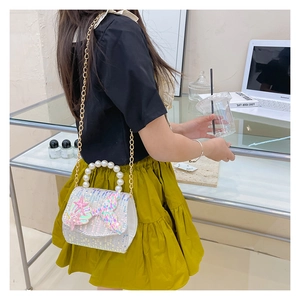 Detail of girls mermaid sequin bag with pearl handle and golden chain strap