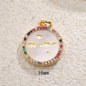 Macro view of a 16mm gold Mama heart pendant with colorful zircons and white shell