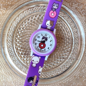 Close-up of girls purple silicone watch band with cute cartoon cat and donut patterns
