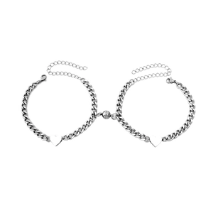 Detail of magnetic silver heart charms connecting two titanium steel cuban bracelets