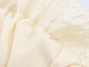 Gros plan détaillé du tissu jacquard crème et de la matière soyeuse et lisse