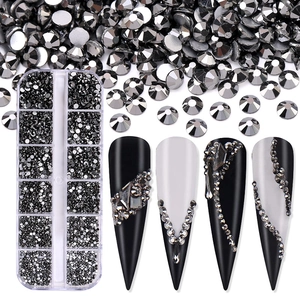 Close-up of 12-grid storage box with grey nail art rhinestones and decorated nail tips