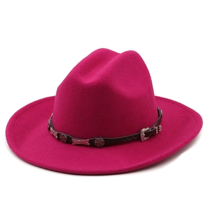 Detail of rose red wool felt cowboy hat featuring black leather band and silver star accents