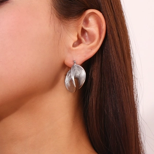 Macro shot of silver tiered spiral earrings featuring a textured grooved metal design