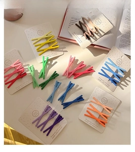 Detailed close-up of colorful X-shaped hair clips in candy colors on display cards