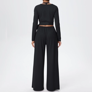 Détail de l'ensemble de yoga noir avec haut à manches longues noué et pantalon taille haute