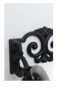 Detailed close-up of retro cast iron wall hook featuring scrollwork and sandblasted texture
