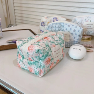 Detailed macro of quilted cotton makeup bags with floral patterns and zipper closure