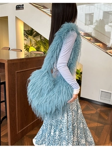 Detail of fluffy sky blue faux fur shoulder bag with long plush fringe texture