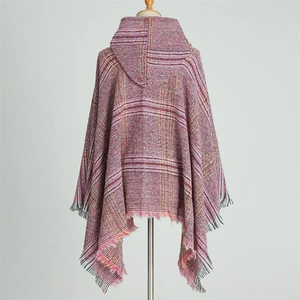 Detail view of red, pink, and yellow plaid knit hooded poncho with fringed hem on mannequin