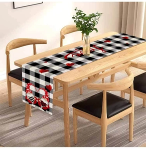 Detail of linen table runner with red hearts and gnome print over black and white plaid