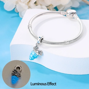 Luminous blue seashell pendant charm on silver snake chain bracelet close-up view