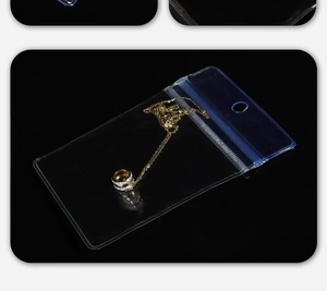 Macro detail of transparent PVC jewelry bag with blue seal strip and gold necklace