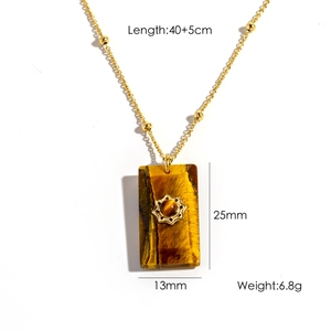 Macro detail of rectangle tiger eye stone pendant with starburst on golden steel chain