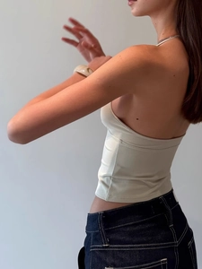 Slim fit halter top in cream color with open back design and ribbed knit texture