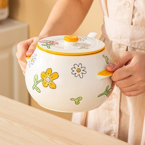 Japanese style floral ceramic lard jar with yellow handle and lid shown in kitchen setting