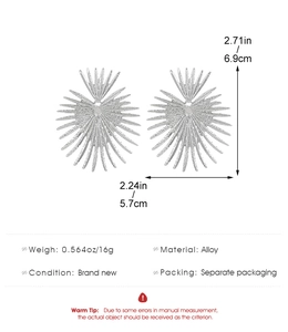 Detalle de pendientes grandes de sol plateados con medidas de 6,9 cm y peso de 16 g