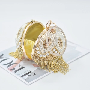 Detail of sphere evening bag with pearls, rhinestones, tassels and yellow silk lining