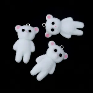 Close-up of three white flocked bear charms with pink accents and silver metal rings