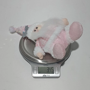 Pink plush Santa Claus hanging ornament being weighed at 34.5g on a digital scale