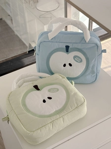 Macro view of blue and green soft padded cosmetic bags with white apple patterns