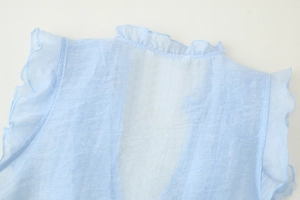Detail of light blue sleeveless chiffon top featuring ruffled neck and pleated texture