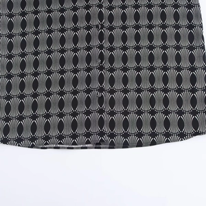 Detailed close-up of geometric fan pattern fabric and stitching on black women shirt