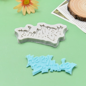Silicone Happy Birthday cake mold for DIY chocolate and baking decoration on green surface