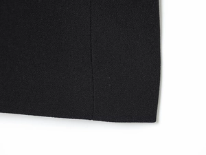 Detailed macro view of black textured fabric with precise vertical stitching on the hem