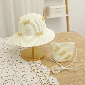 Close-up of straw hat and matching bag set with yellow lace bows for summer sun protection