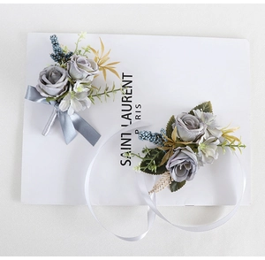 Detailed set of blue silk rose boutonniere and wrist corsage for elegant wedding events