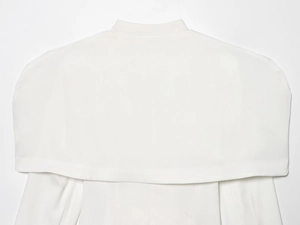 Detailed back view of white tweed jacket featuring a wide cape-style shoulder design