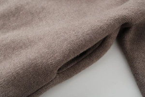 Detailed close-up of brown knit fabric texture and premium pocket stitching on the jacket